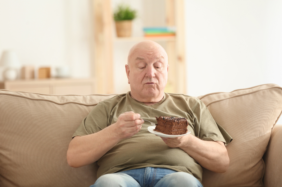 Overweight man eating cake